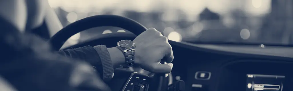 Gün batımında direksiyon başındaki sürücü